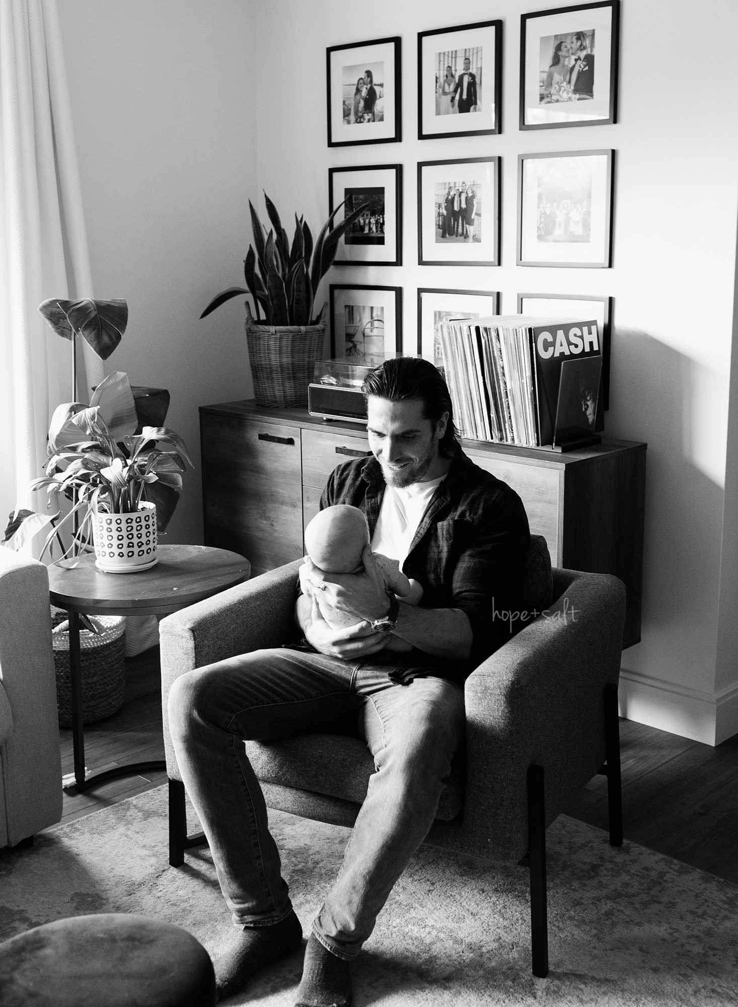2 month old baby boy in dads arms with records players johnny cash - lifestyle session - burlington newborn photographer