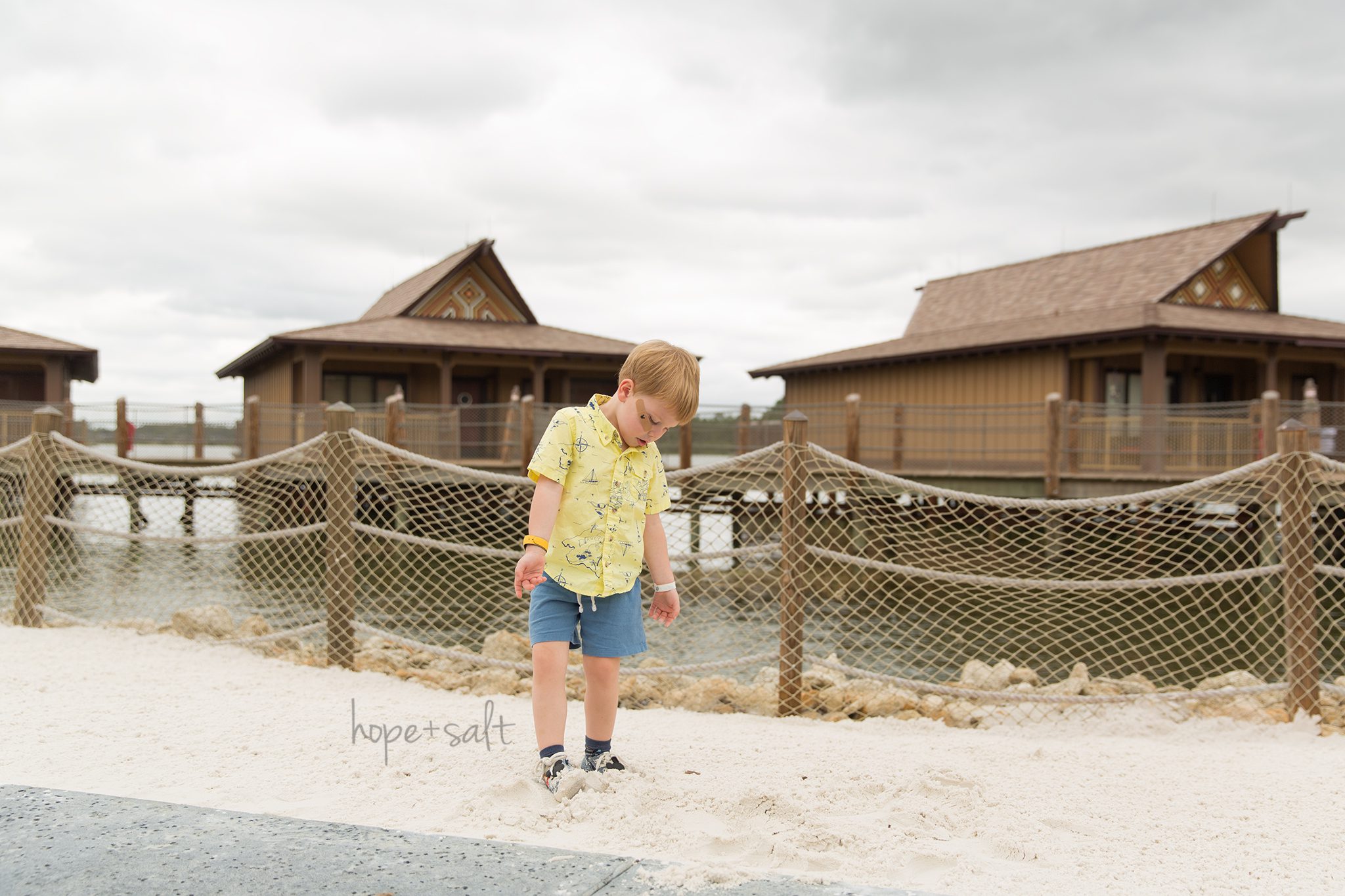 Walt disney world polynesian beach three year old boy in nautical shirt and mickey shoes burlington family photographer
