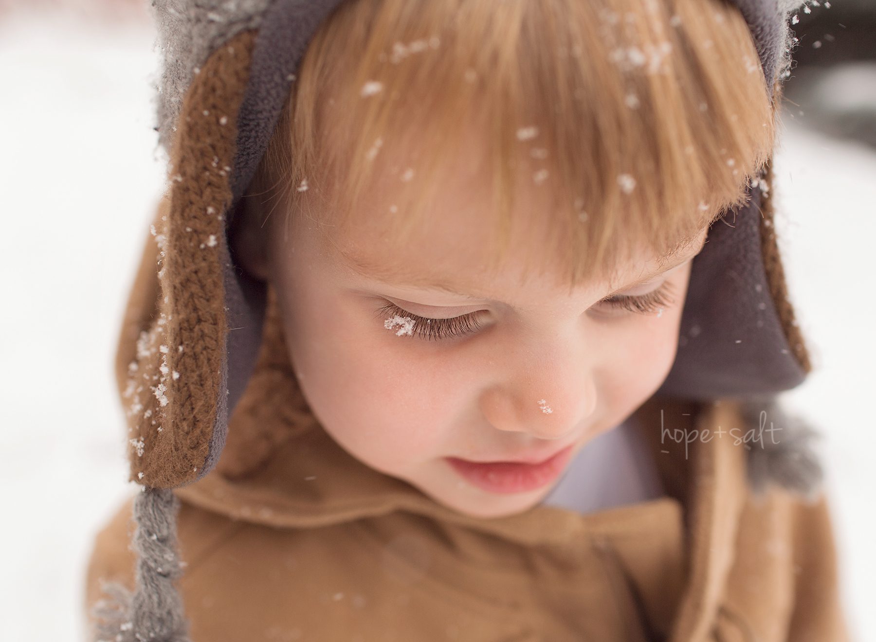 Image of child toddler boy with snowflakes on his lashes and nose burlington family photographer