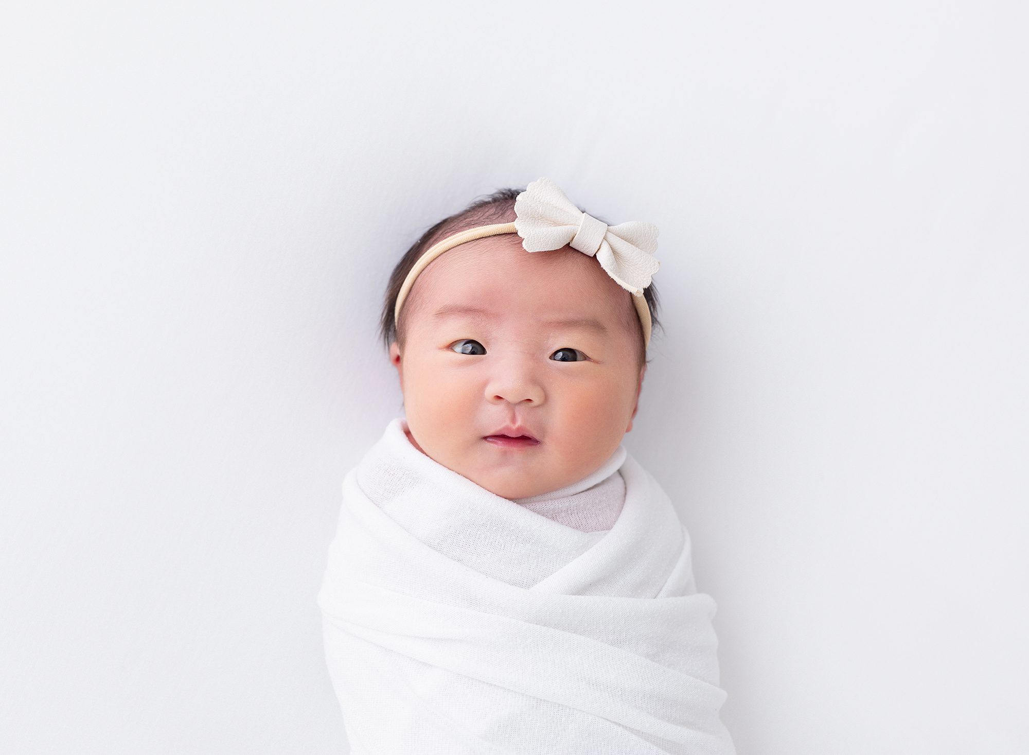 in-studio newborn girl baby L headshot white swaddle on blankets mississauga ontario photographer